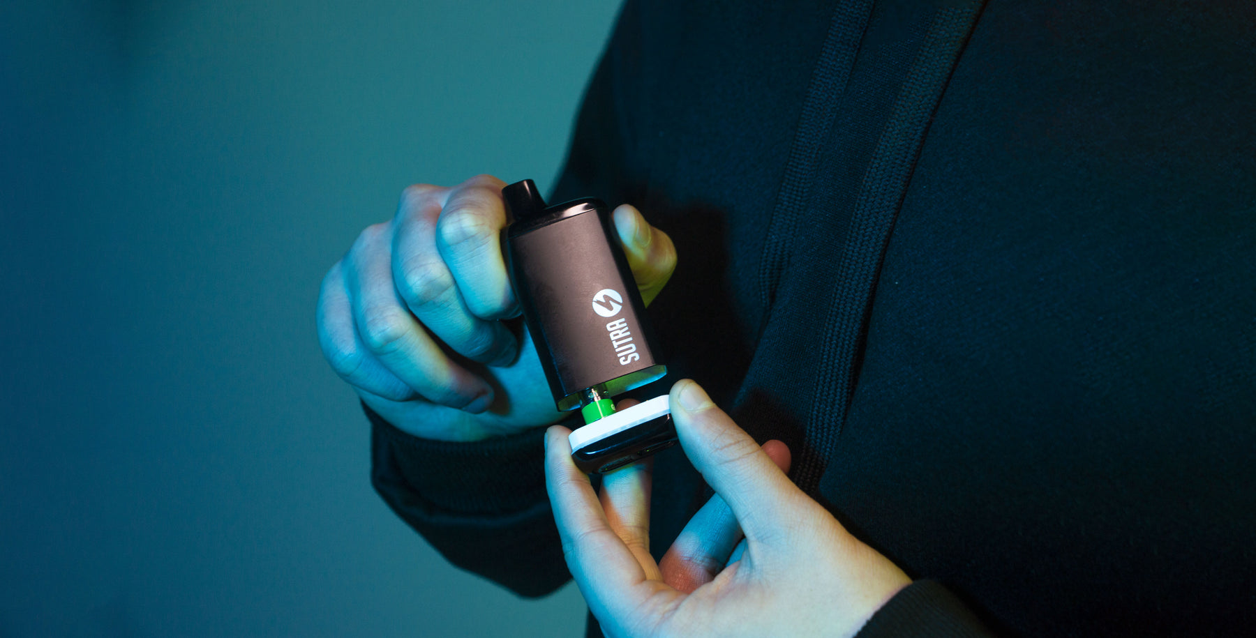 Man holding Sutra SILO Pro in front of blue studio background 